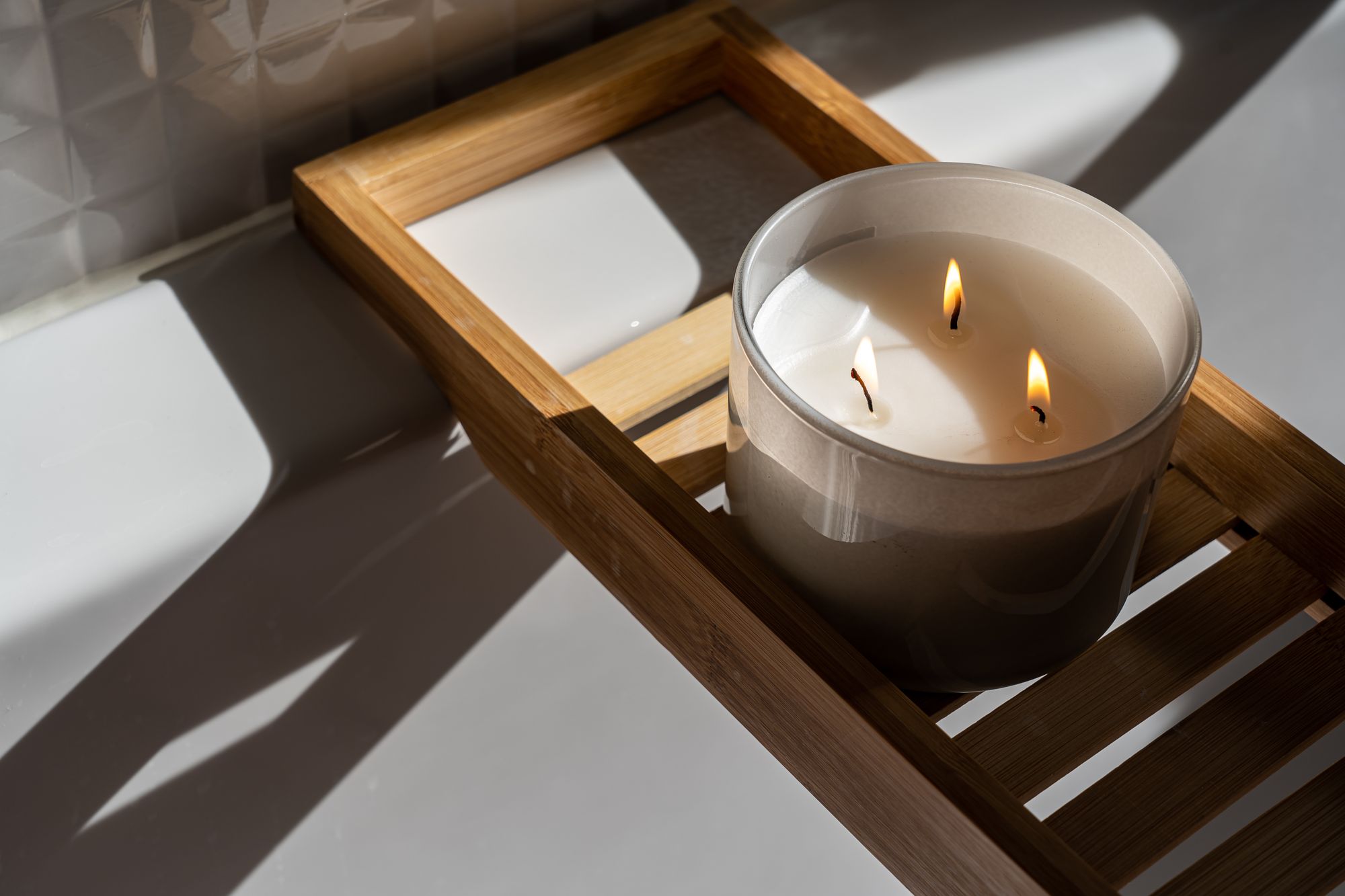 Unlit candle on a wooden tray in warm shadow