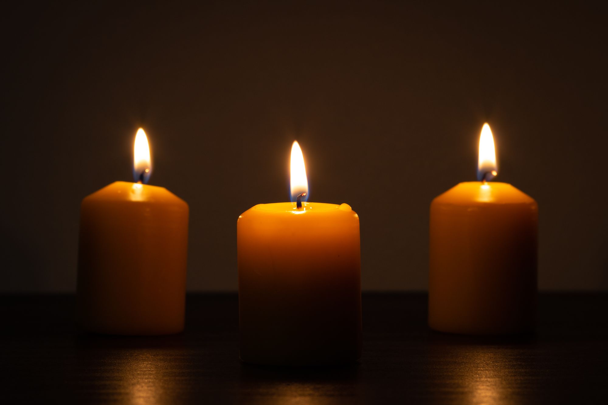 Candles glowing softly in a dark, warm room