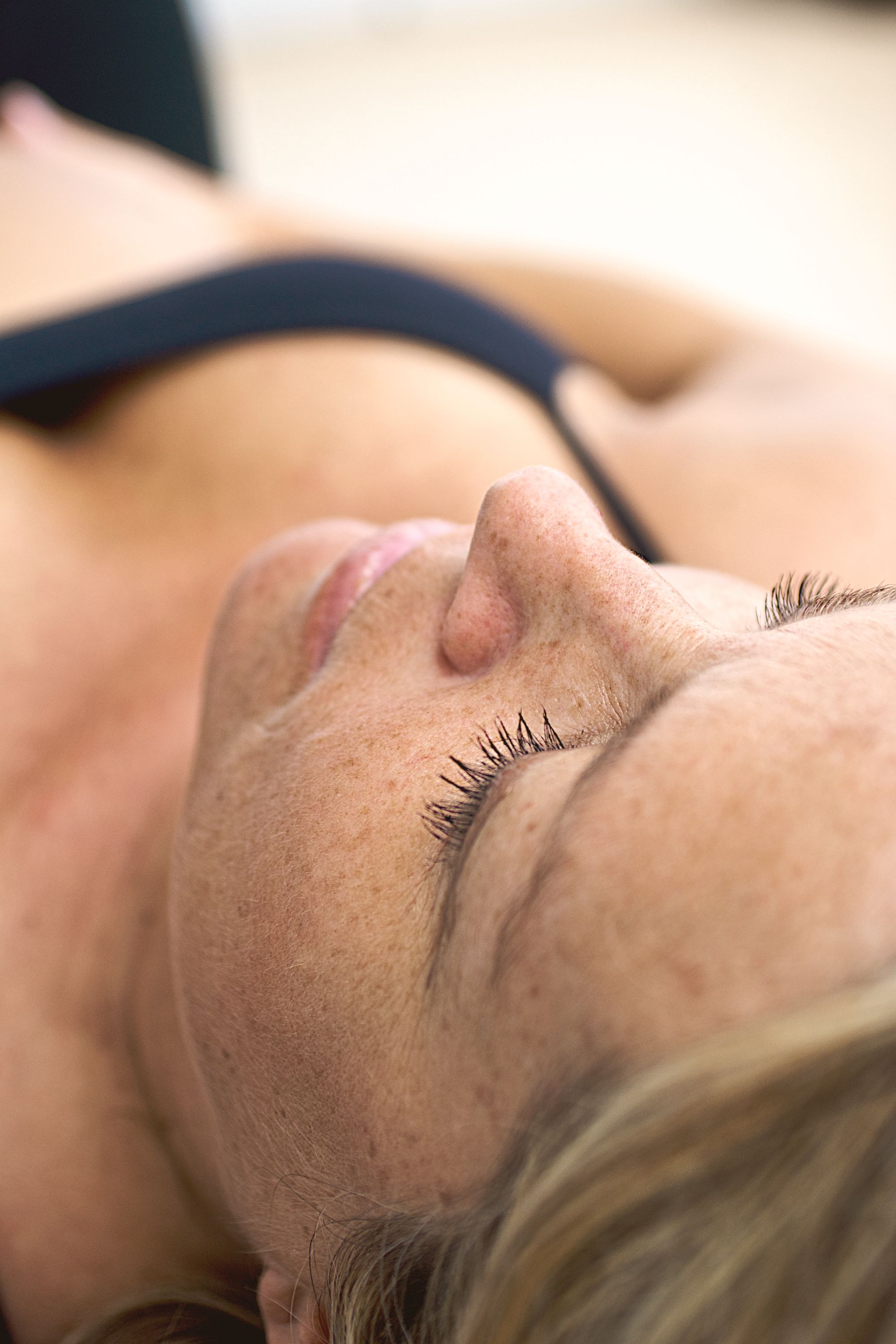 A woman resting with closed eyes in warm light